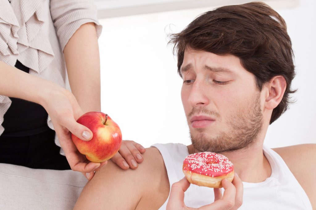 Man choosing junk food instead of healthy food