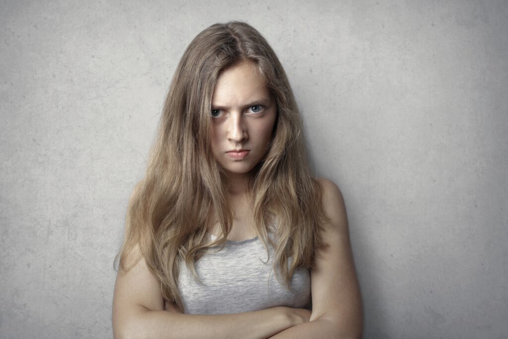 Scowling young woman with arms folded