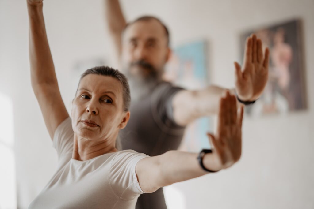Older man and woman doing some kind of movement practice, appearing strong and powerful