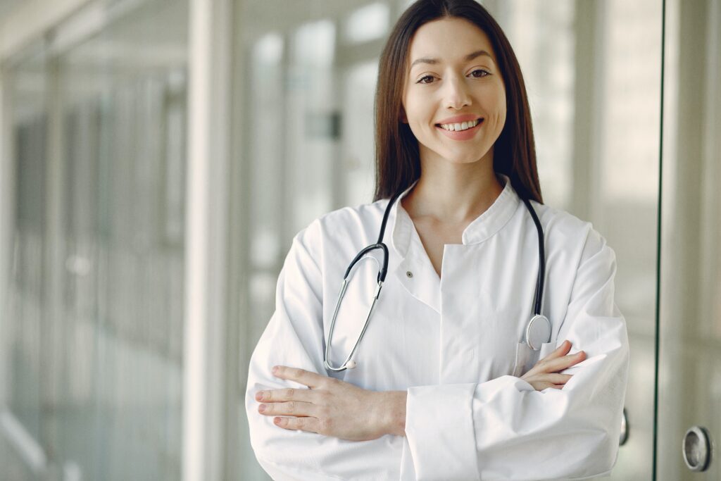 Young woman doctor in white coat with stethoscope